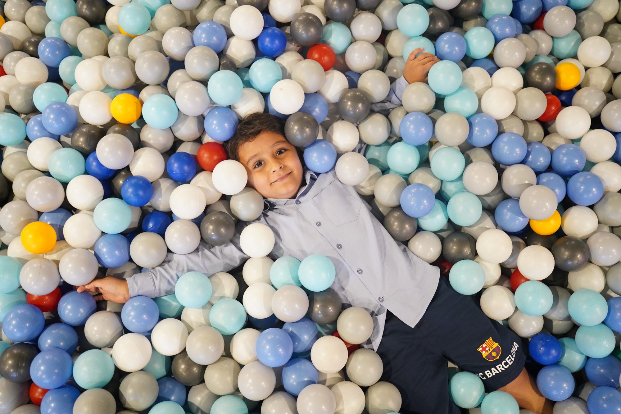 Kid lying in the ball pit